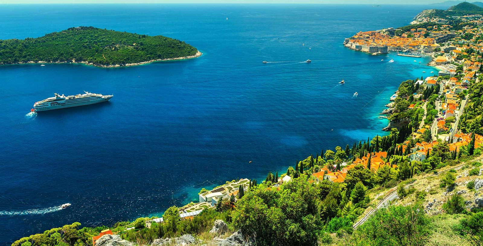 Small cruise ship sailing a Mediterranean coast